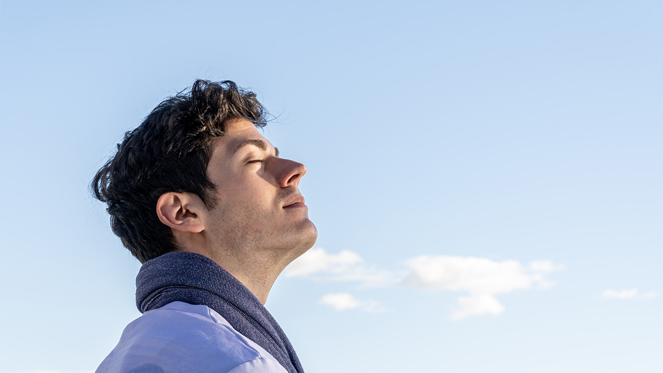 boy with eyes closed and sky