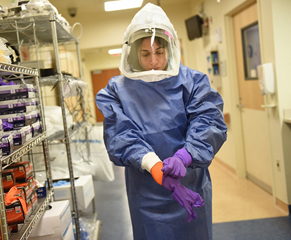 A medical worker dons personal protective equipment. Credit: National Institutes of Health