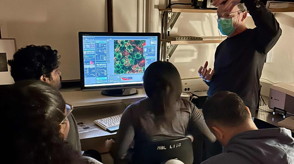 Bootcamp faculty Rick Fehon (standing) imaging cell division in the larval fly brain on the Zeiss LSM 780 with students Pavan Rao, Trinity-Paris Foster, Amina Bradley, and Christian D. Del Valle Colón. 