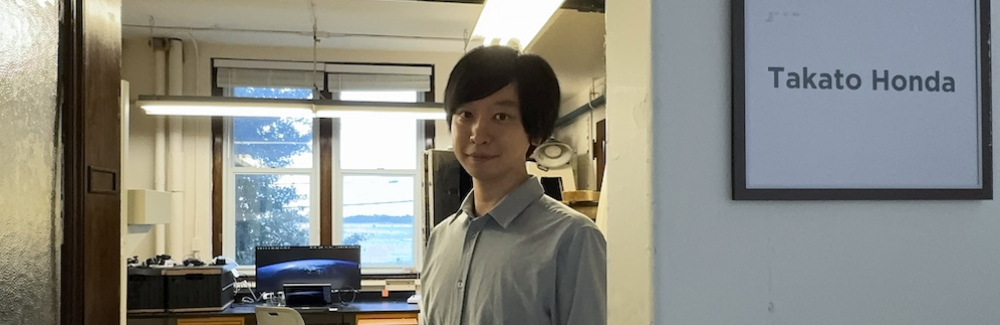 A scientist stands in front of his lab