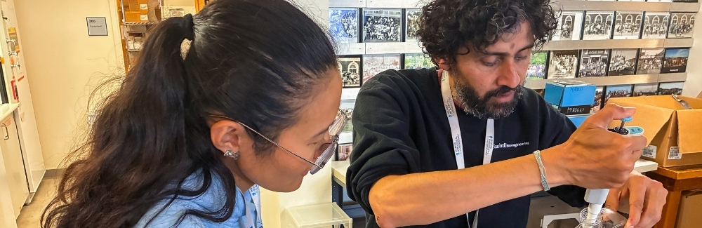 Two scientists prepare a sample in the lab