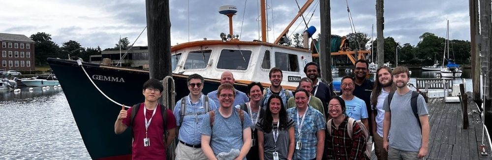 A group of scientists in front of a research vessel