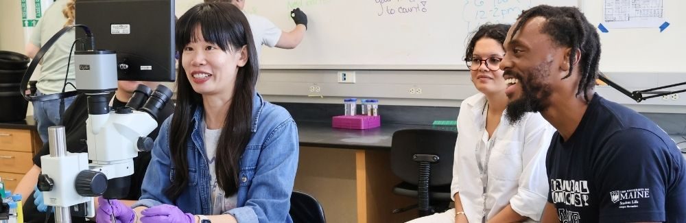 MOMY student Jinhong Xie learns to dechorionate zebrafish embryos as Caroline Almeida, and N’namdi Baker look on. Image credit: Lindsey Lubofsky