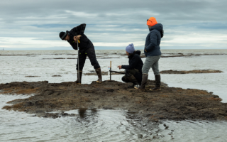 Three scientists take a soil sample site at the edge of a Beaufort Sea lagoon, part of the greater Arctic Ocean on the northern coast of Alaska. Credit: Nathaniel Wilder