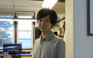 A scientist stands in front of his lab