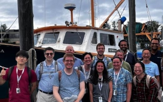 A group of scientists in front of a research vessel