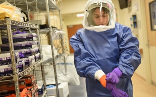 A medical worker dons personal protective equipment. 
