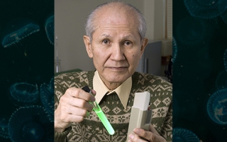 Osamu Shimomura holds a test tube containing green fluorescent protein (GFP) in a water solution. 