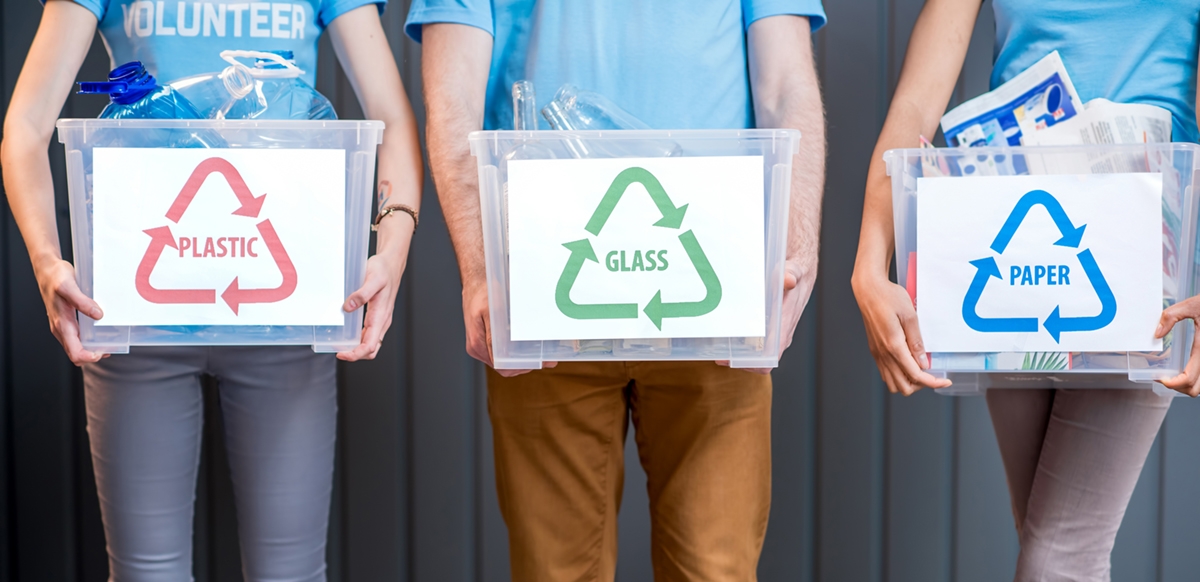 people holding recycling containers
