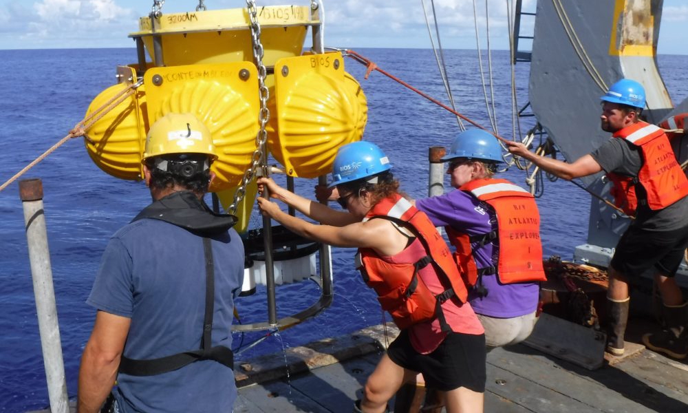 Rut Pedrosa Pàmies (center left) and Maureen Conte (center right) with crew of the R/V Atlantic Explorer recover a deep-ocean sediment trap on the OFP mooring in the Sargasso Sea, off of Bermuda. Credit: J.C. Weber