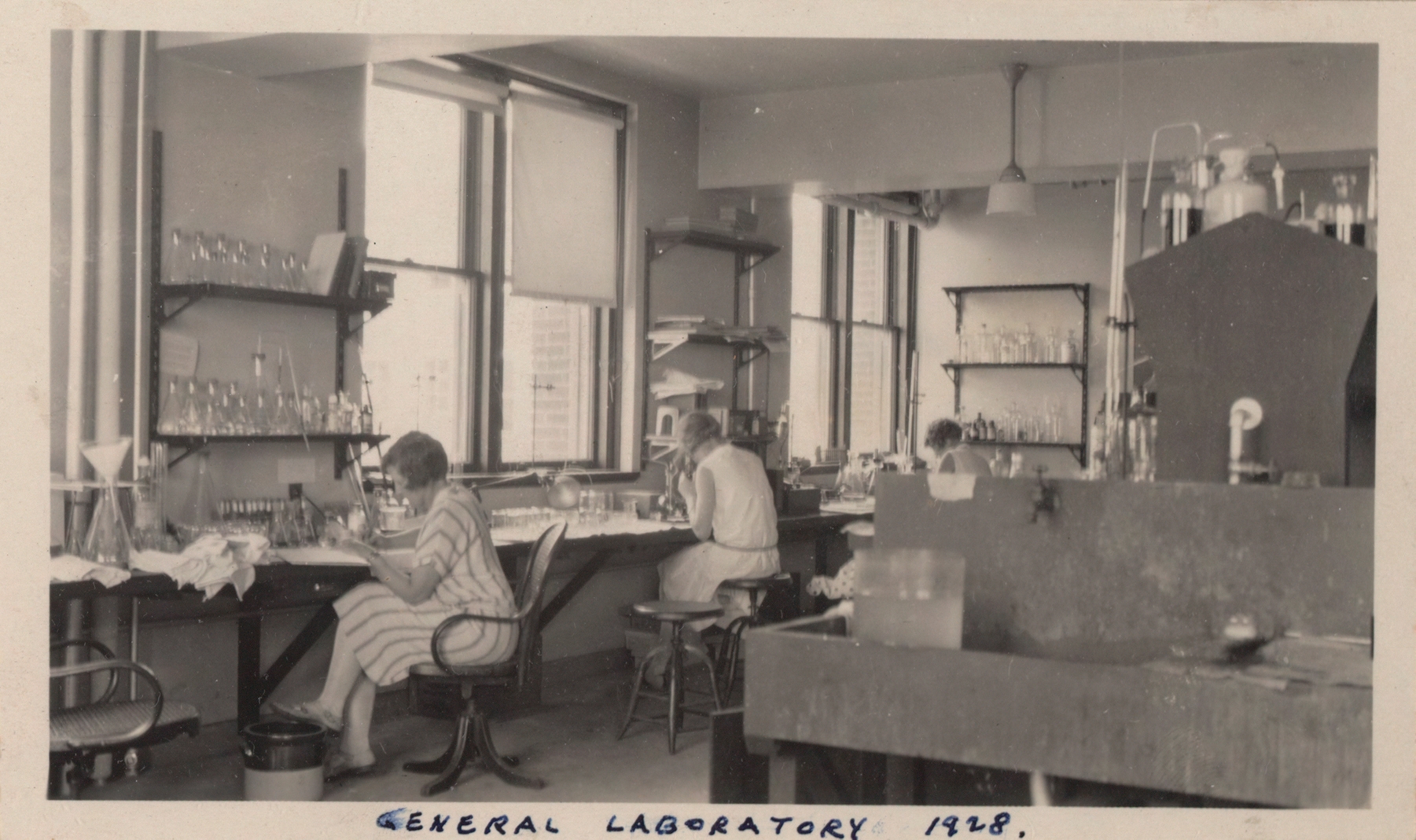 A black and white image of women working in the lab. Labeled General Laboratory 1928