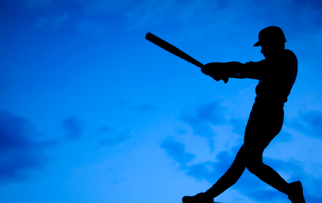 Baseball player in silhouette against the sky