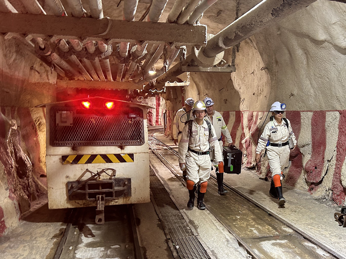 Researchers utilizing an underground train to access an active South African goldmine.