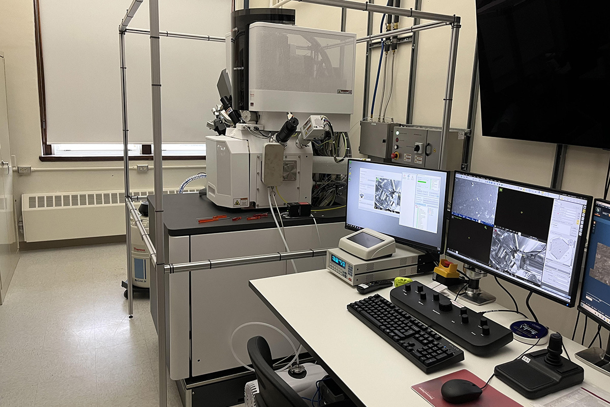 Microscope with computer and multiple monitors.