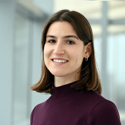 Smiling woman with dark shoulder length hair wearing a maroon turtleneck.