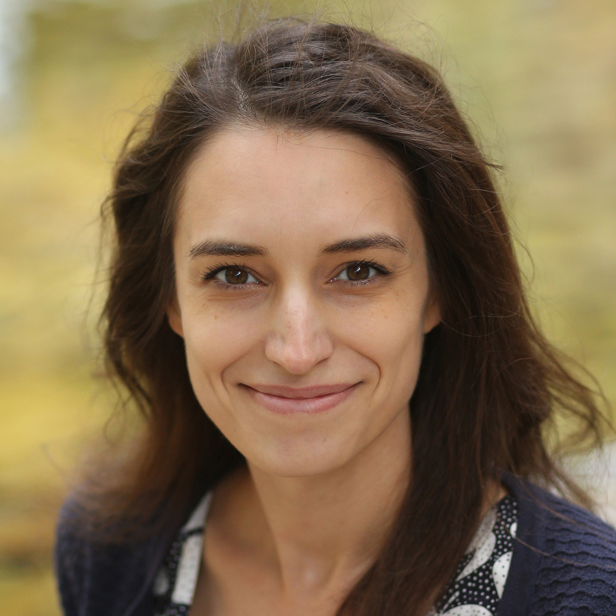 Smiling white woman with long, dark hair.