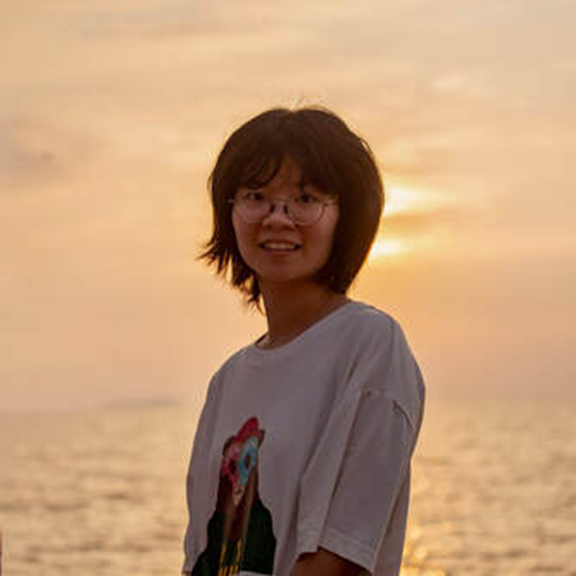Female presenting person at the ocean at sunset.