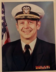 Male presenting person in Navy uniform.
