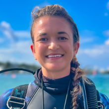 Smiling female-presenting person in dive gear.